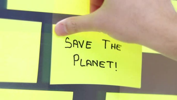 拯救地球后it概念。商人在会议室的玻璃上贴了一个便利贴。