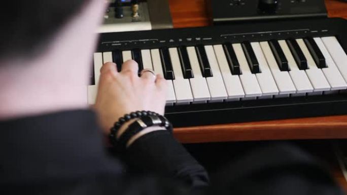 在音乐工作室用钢琴midi键盘演奏。音乐创作过程。流行歌曲作曲家为音乐专辑创作新歌。家庭音乐录音棚概