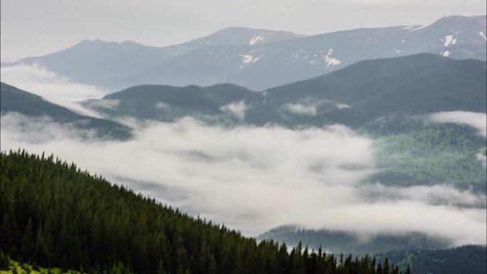 在山上覆盖的森林上移动的云层阴影的俯视图。延时