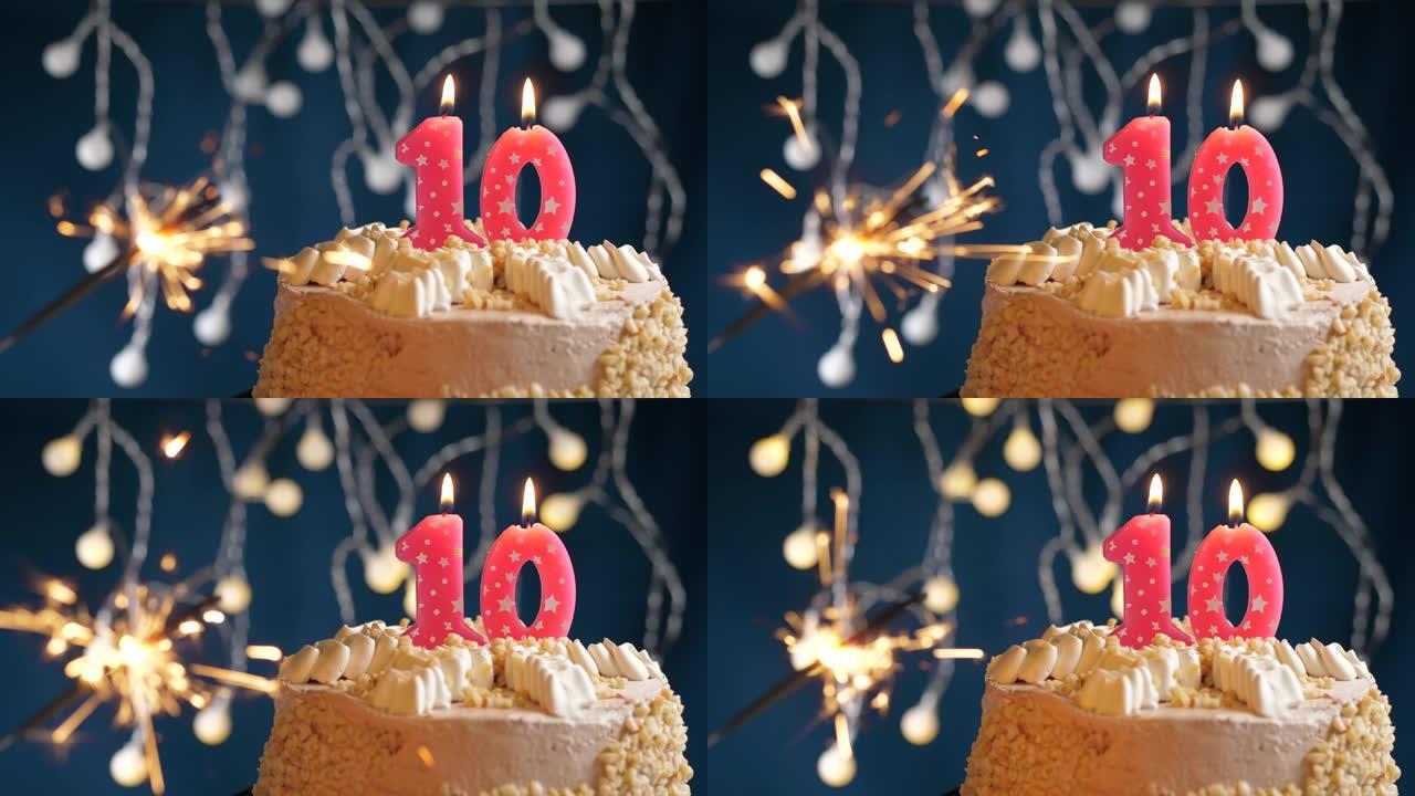 生日蛋糕，蓝色背景上有10个数字粉色蜡烛和烟火。慢动作和特写视图
