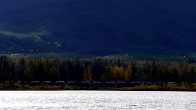 加拿大班夫秋季沿河行驶的货运列车