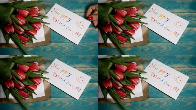 木桌上的生日快乐留言便笺和郁金香花束的俯视图。爱情关系概念。生日概念。4 k拍摄