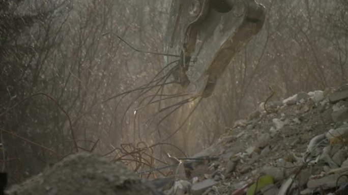 建筑物拆除。一个巨大的机器手臂摧毁了房子。灰尘、碎片、砖块、碎片飞下来。