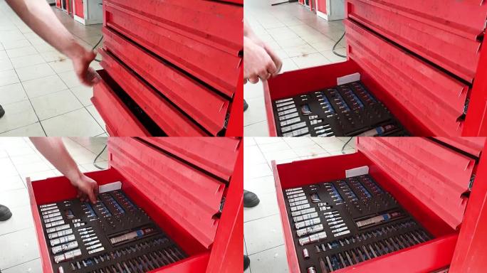 车库里的机械师把工具放在红色金属盒里，特写镜头