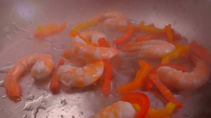 虾和胡椒掉在锅上的热油中