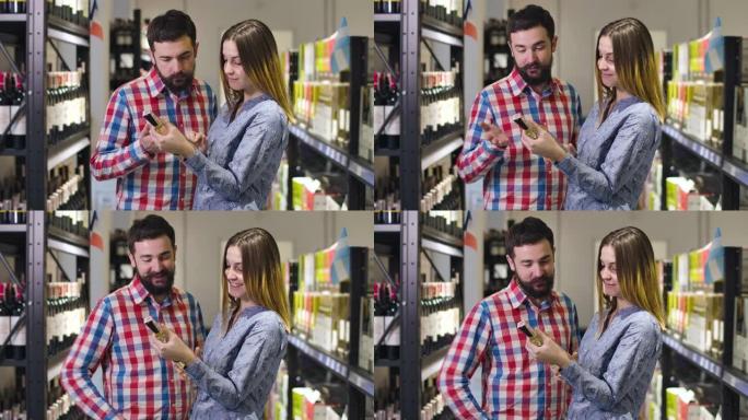 微笑的高加索夫妇在豪华商店中阅读标签时选择葡萄酒的中间镜头。年轻的男朋友和女朋友晚上选择喝酒。生活方