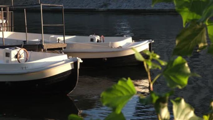 阳光明媚的一天，两条白色的塑料船在河上。