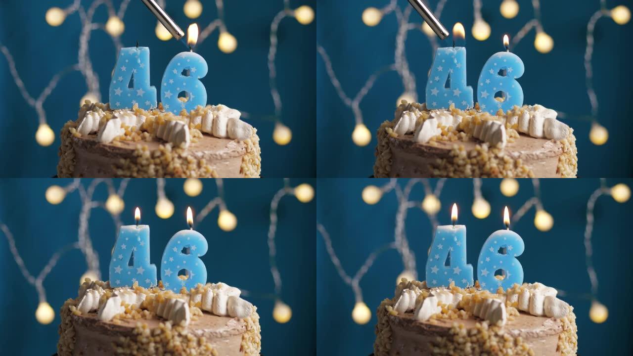 蓝色背景上有46号蜡烛的生日蛋糕。蜡烛着火了。慢动作和特写视图