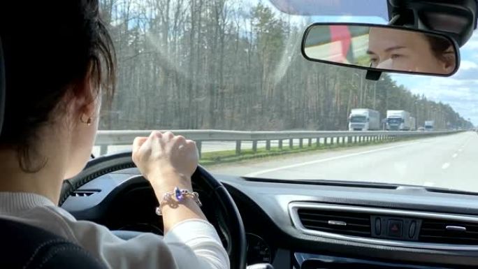一名妇女在去另一个城市的公路旅行中开车。