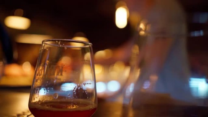 酒吧桌上的啤酒杯背景虚化虚焦玻璃高脚杯酒