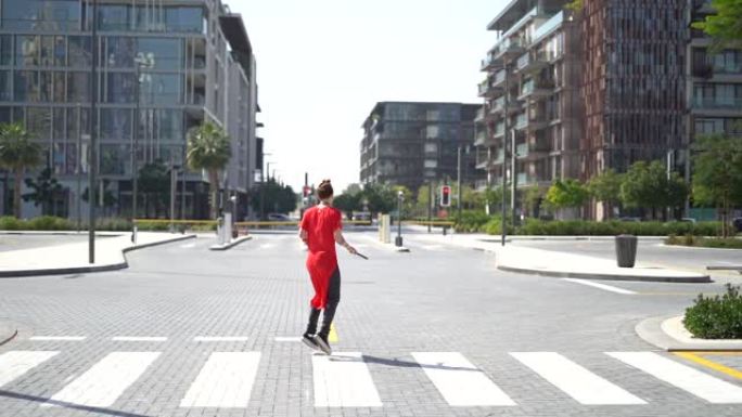 年轻女孩在慢动作中跳绳与迪拜城市背景的人行横道上跳跃