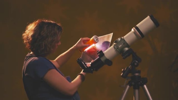 孕妇通过望远镜看着星星-占星术概念，关于婴儿的星座预测。