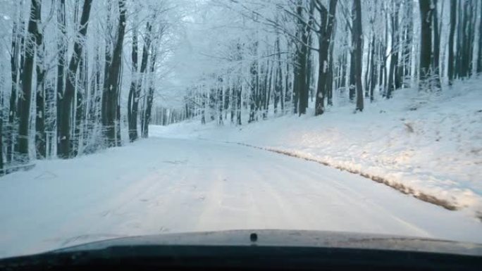 汽车视点在夜间积雪覆盖的道路上行驶，第一场雪落下。