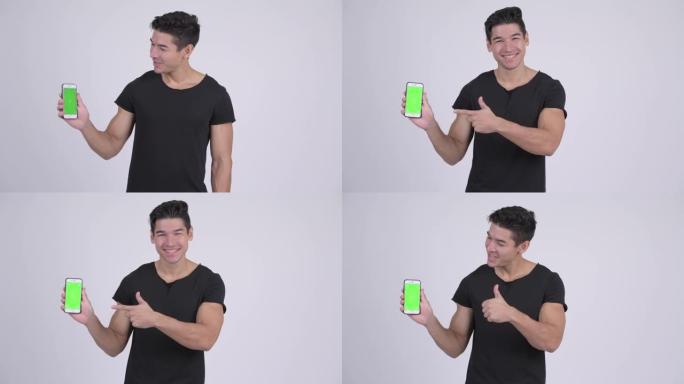 快乐年轻英俊的多民族男人展示电话