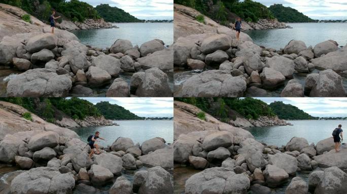 背包旅行者走在海边的岩石上