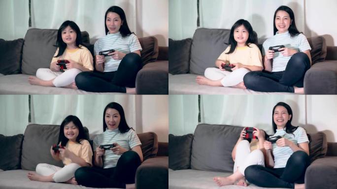 幸福亚洲家庭一起玩游戏机妈妈和女儿带着快乐的乐趣退出享受沙发家庭背景下的夜间活动