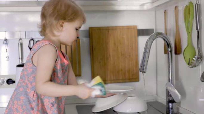 小女孩在家用厨房水槽用海绵洗碗