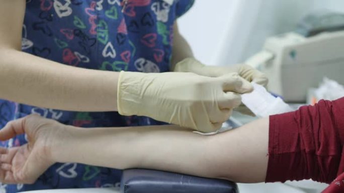 病人在验血前用手抽血。护士用酒精羊毛擦拭静脉。在疫苗接种计划的特写镜头中，护士向患者静脉注射药物。