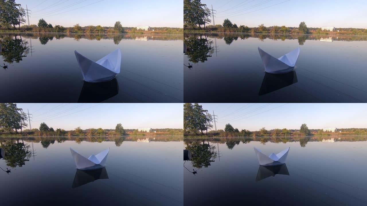 白色的船漂浮在平静的池塘湖光滑的镜面上