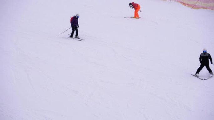 滑雪者和滑雪者在滑雪胜地的雪坡上骑行