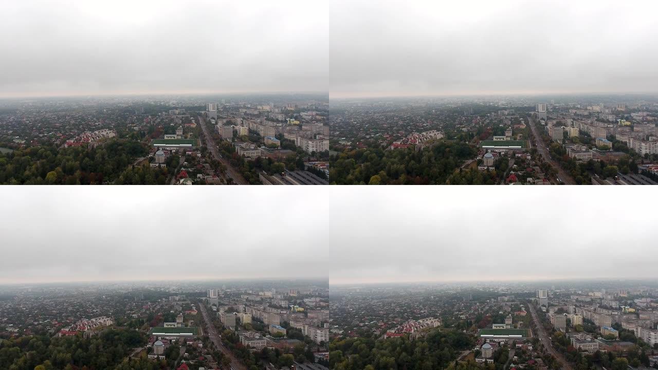在低层云雾中的小镇无人机镜头。在雾云掠过的城市中拍摄的俯视图。云雾中的城市景观鸟瞰图