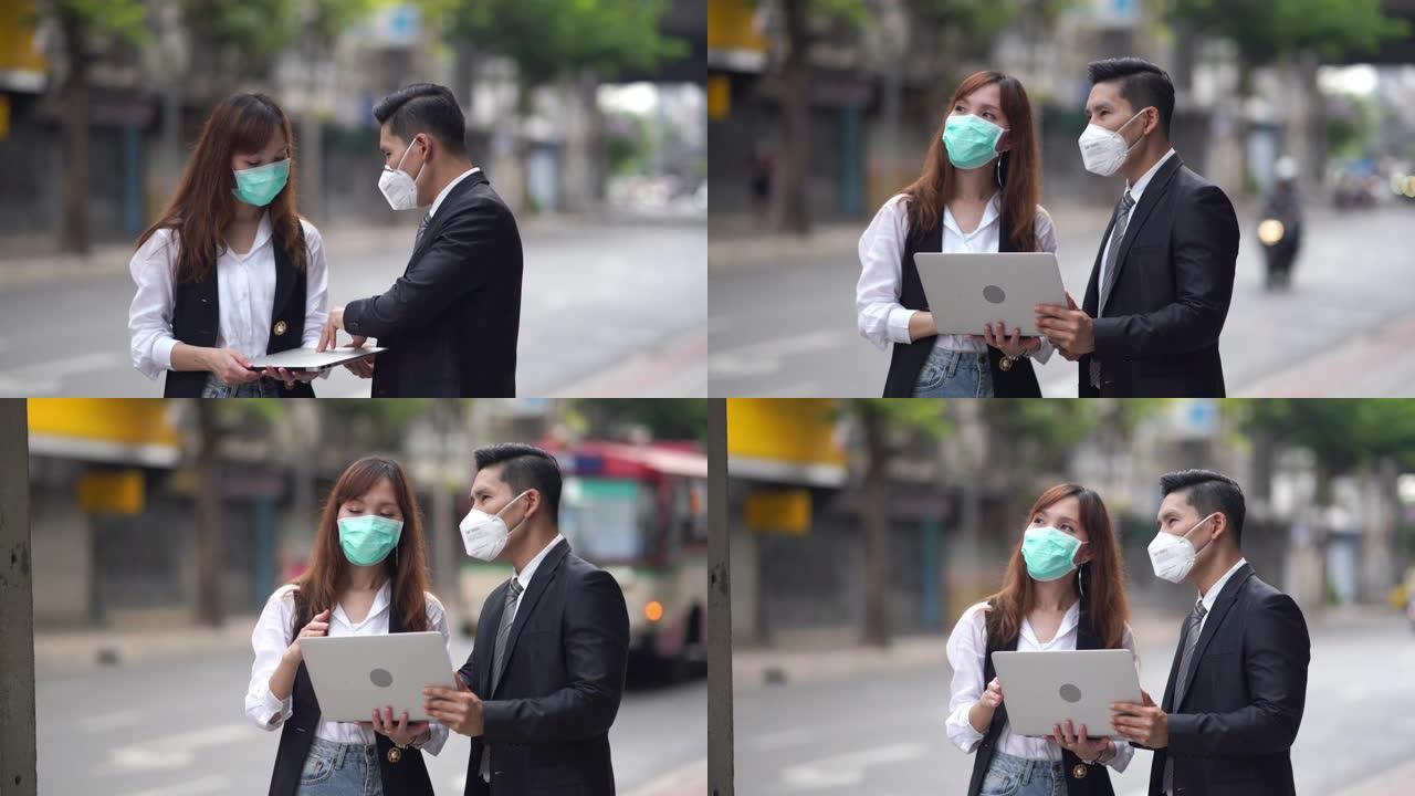亚洲商业团队讨论笔记本电脑和戴口罩保护污染或电晕病毒