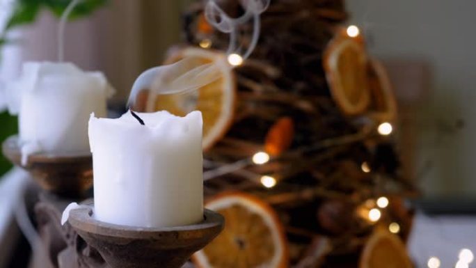 两支发光的白色圣诞蜡烛，背景为枞树和模糊的闪闪发光的灯光。熄灭的蜡烛火焰。4K