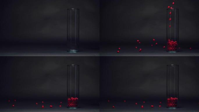 红色糖果落在慢动作的玻璃花瓶中，黑色黑板纹理背景上的复制空间