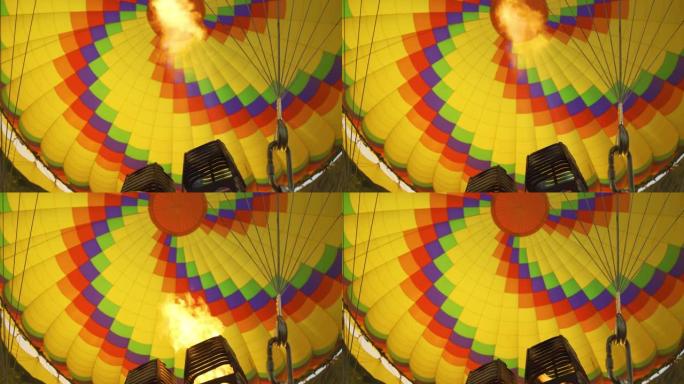带有热火焰的燃烧器的特写镜头照亮了飞行的热气球内部