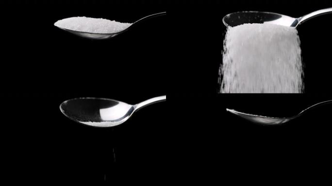 糖落在黑色背景上的勺子上