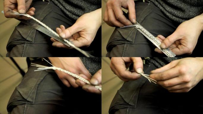 编织银手镯的特写，珠宝大师的手制作新产品，选择性聚焦