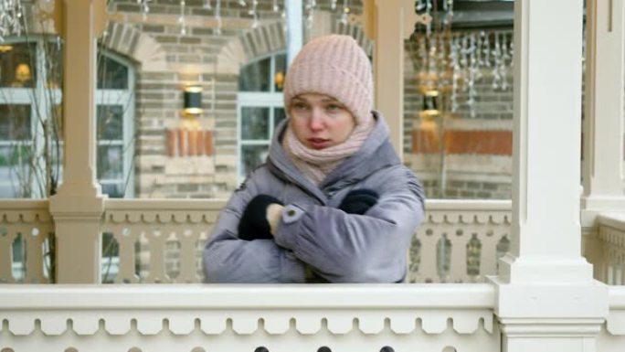 烦恼和愤怒的年轻美女的特写镜头在冬天的户外等待她的男朋友时冻僵了。4K