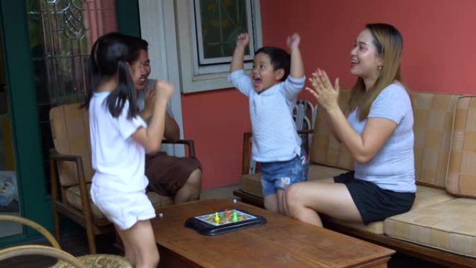 亚洲家庭在室内放松在家玩骰子游戏