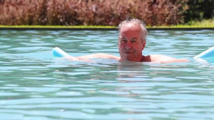 老人在游泳池放松漂浮快乐