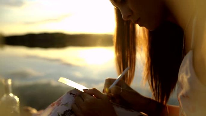 姑娘在码头上写留言，在瓶子里写留言，美丽的秋日