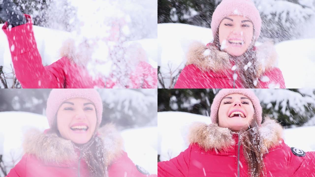 一个开朗的年轻女子在冬季散步时扔雪，并在飘落的雪中欢欣鼓舞。