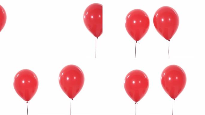 两个红色气球在空中飞行并彼此分离的特写演播室拍摄。孤立，在白色背景上。
