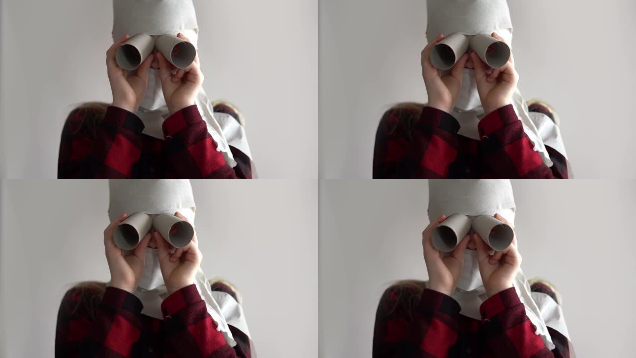 有趣的视频-由于冠状病毒的流行而被隔离。戴着卫生纸面具的女孩在灰色背景上摆姿势。