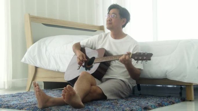 资深亚洲男子演奏的原声吉他。
