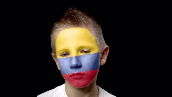 哥伦比亚足球队的伤心球迷。脸上涂着民族色彩的孩子。