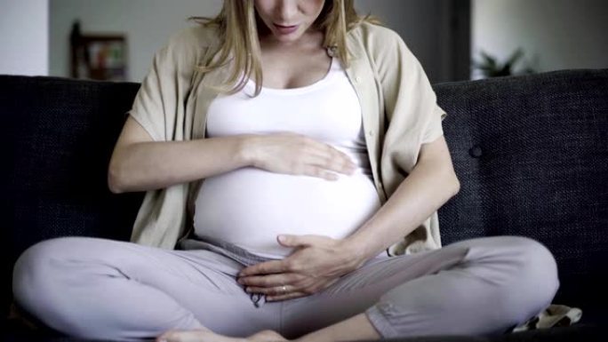 孕妇按摩腹部和说话的前视图