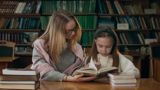 两个女孩正在图书馆的阅览室看书。4k超高清