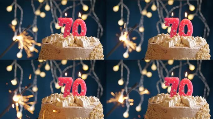 生日蛋糕，蓝色背景上有70号粉色蜡烛和烟火。慢动作和特写视图