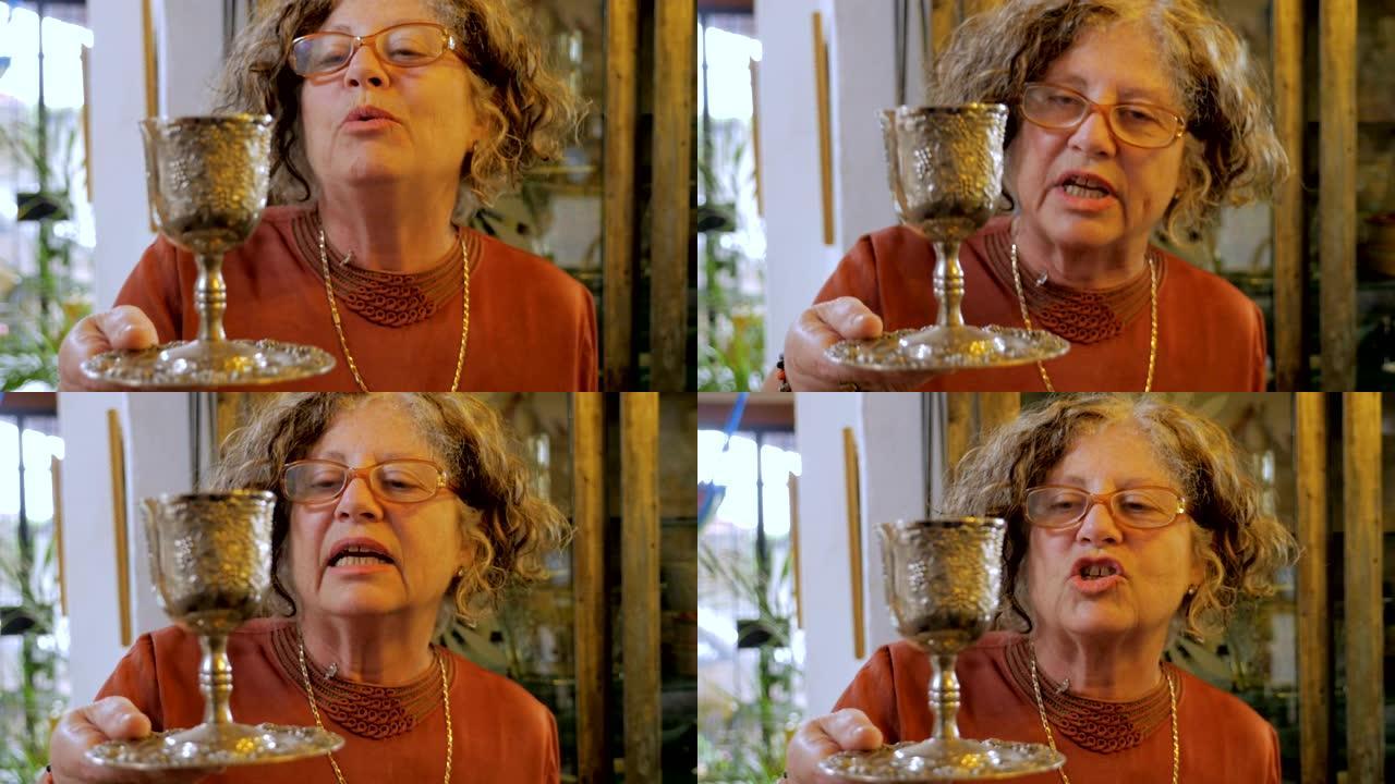 一位有吸引力的年长犹太妇女解释了kiddush杯