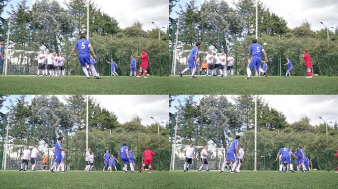 穿着蓝色和白色制服的老年男子足球队正在进行一场比赛，其中一名球员收取任意球，其他人则负责