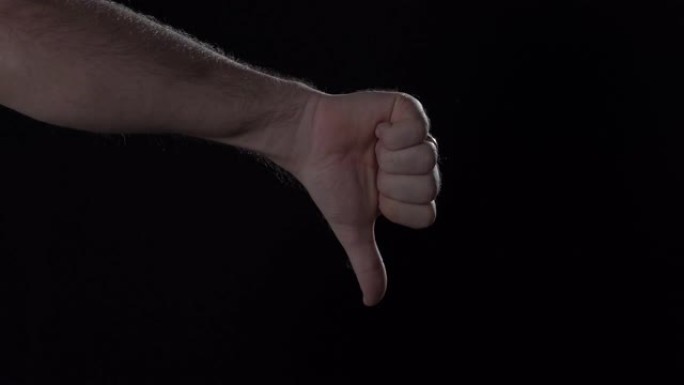 男人的手在黑色背景上显示拇指向上和拇指向下的手势。停电，4K