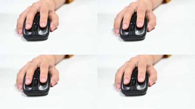 一个亚洲女人的4k特写手使用白色无线鼠标。女性手点击白色桌子背景上时尚的无线鼠标按钮。