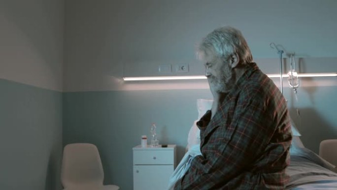 悲伤绝望的老人独自坐在医院的病床上