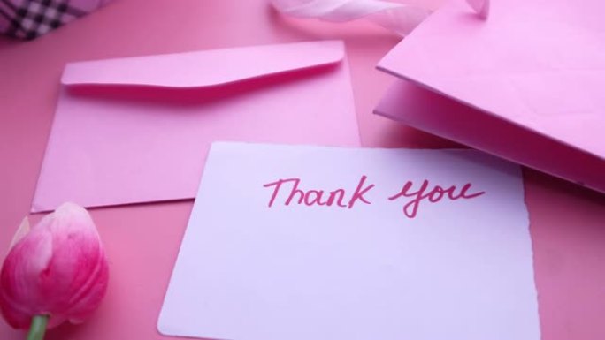 带有礼品盒粉红色背景的感谢信