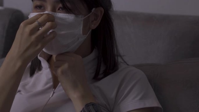 4k亚洲沃金妇女戴上白色面具，坐在沙发上，白衬衫上衣，医用防护面具，埃博拉MERS传染性非典型肺炎，